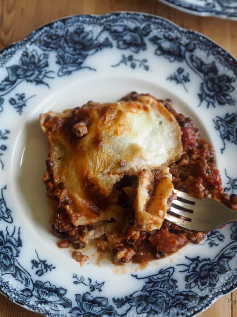Et stykke beluga lasagne med en gaffel på tallerkenen