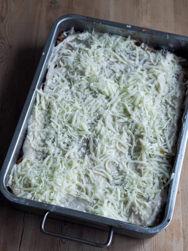 grøntsagslasagne der er ved at blive samlet med ost oven på
