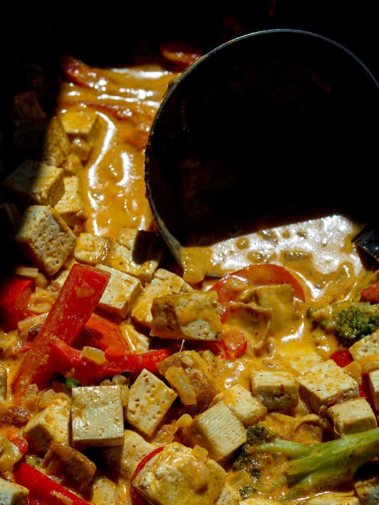 billede af en wok tæt på med rød karry med tofu