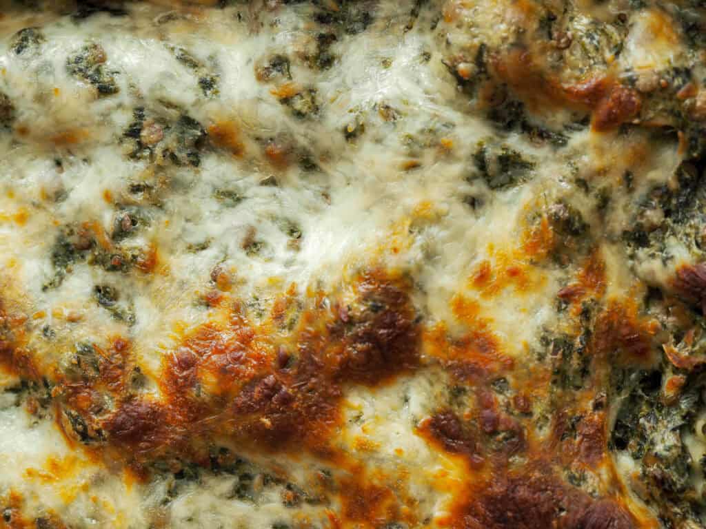 Close up billede af spinatlasagne med grønne linser