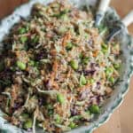 quinoasalat med mange grøntsager og peanutbutter dressing i et stort fad